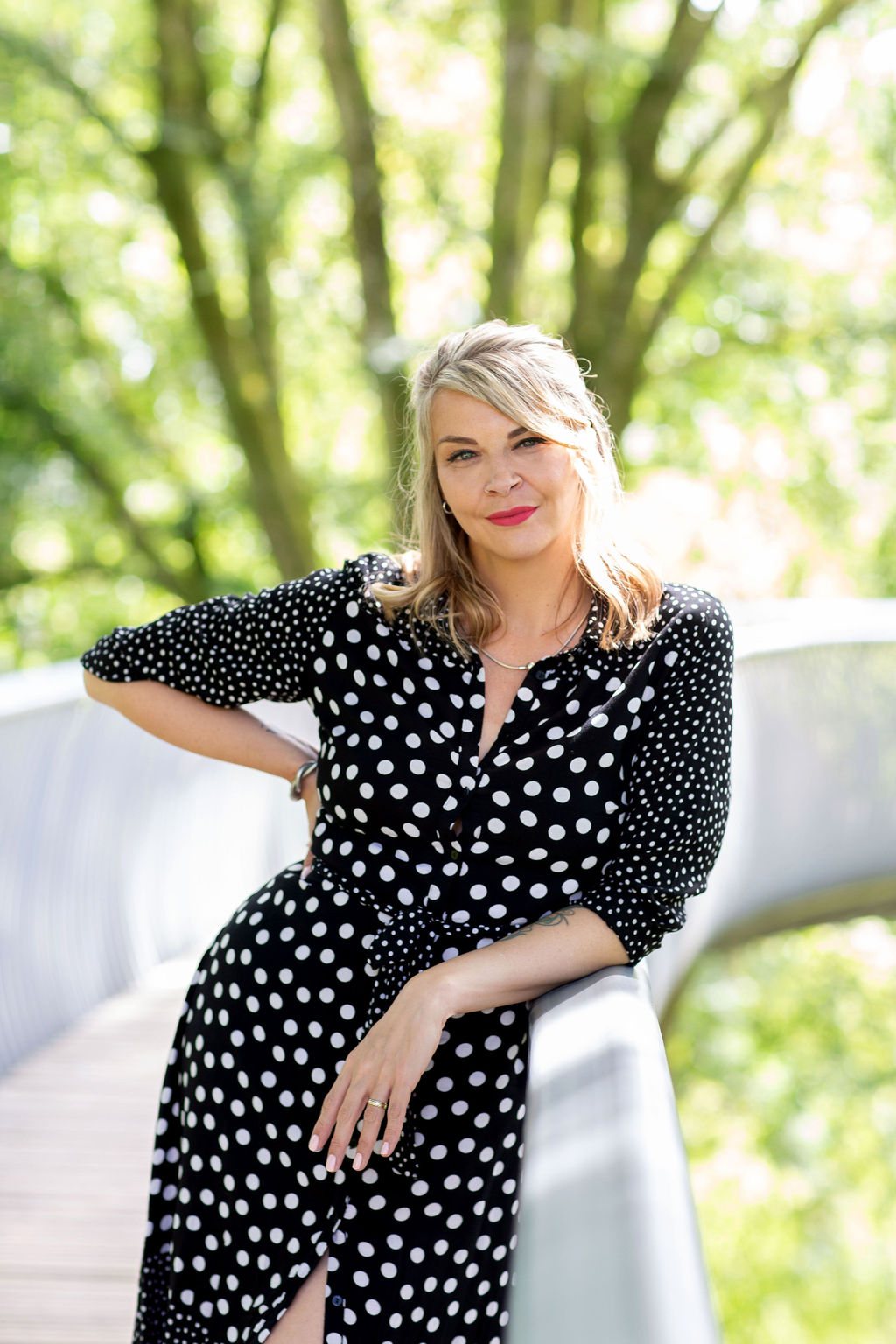 Jade Proudman, founder of Fox & Frog, standing on a footbridge among trees